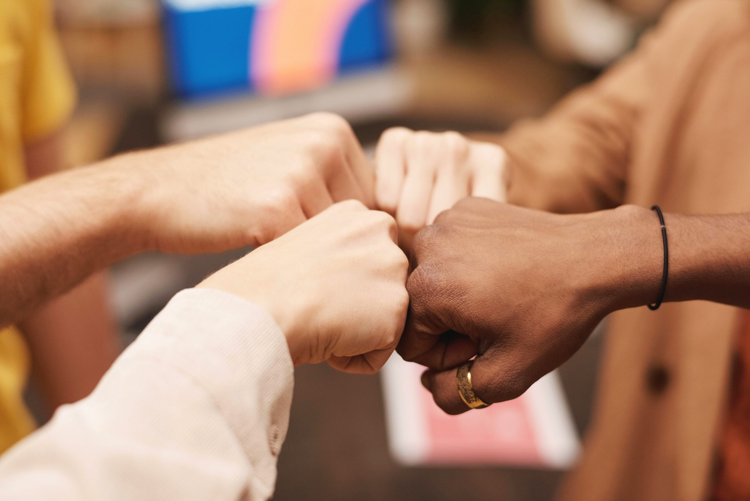 Four hands with fists touching
